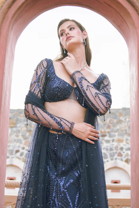 A navy embellished set with a structured blouse, sheer sleeves, and a beaded skirt. Unbreakable is crafted for t