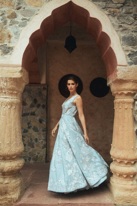 A powder-blue gown adorned with sequins and floral embroidery, designed with a V- neck for modern royalty. Flowing with effortless movement, it’s crafted for statement evenings, soirées, weddings, and modern celebrations.
