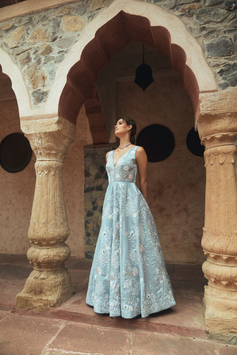 A powder-blue gown adorned with sequins and floral embroidery, designed with a V- neck for modern royalty. Flowing with effortless movement, it’s crafted for statement evenings, soirées, weddings, and modern celebrations.