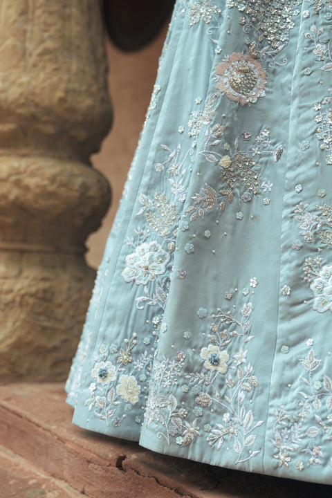 A powder-blue gown adorned with sequins and floral embroidery, designed with a V- neck for modern royalty. Flowing with effortless movement, it’s crafted for statement evenings, soirées, weddings, and modern celebrations.